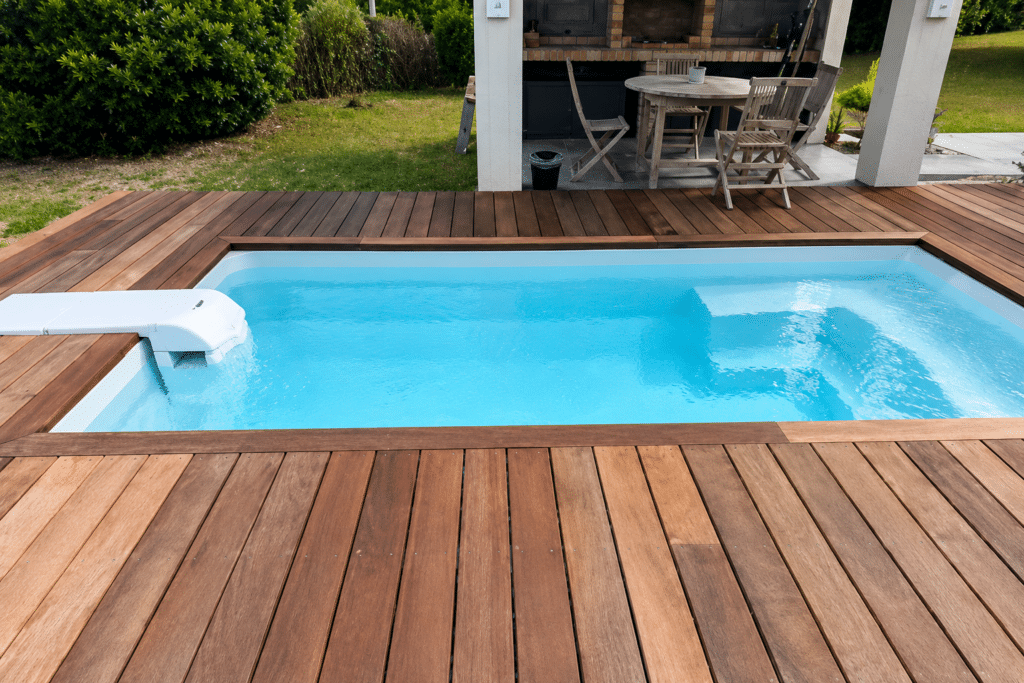 Petite piscine moderne encastrée dans une terrasse en bois exotique avec jardin et patio.